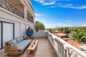 a balcony with a couch and a table at Antarim Resort in Candolim