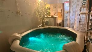 a bath tub filled with blue water in a room at La Clef De Voute Amethyste 