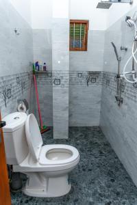 a bathroom with a white toilet and a shower at Kavi Villa in Bentota