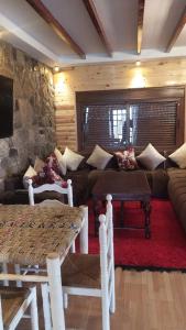 a living room with a couch and a stone wall at Chez karim in Ifrane