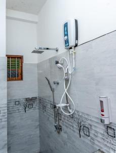 a shower in a bathroom with a shower head at Kavi Villa in Bentota