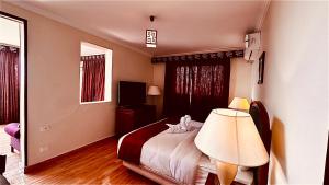 ein Hotelzimmer mit einem Bett und einer Lampe in der Unterkunft PYRAMIDS TOWER Inn in Kairo