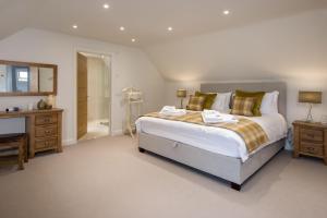 a bedroom with a large bed and a bathroom at Coledale Stables in Kelso