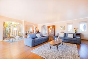 a living room with two blue couches and a table at Villa Eagles Nest by Algarve Vacation in Albufeira
