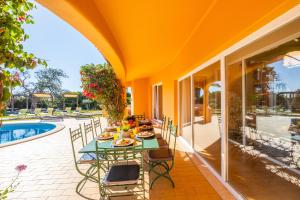 a patio with a table and chairs next to a pool at Villa Eagles Nest by Algarve Vacation in Albufeira