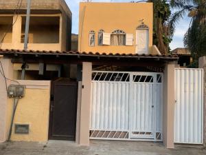 a house with a gate and a garage at Apto Amar - No Espaço Florescer in Campos dos Goytacazes