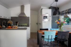 cocina con mesa de madera y sillas azules en Lodge Vlinder Nunspeet Veluwe, en Nunspeet