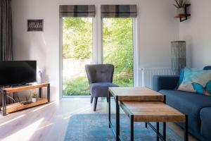 a living room with a blue couch and a tv at Lodge Vlinder Nunspeet Veluwe in Nunspeet