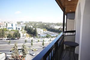 d'un balcon avec une table et une vue sur la rue. dans l'établissement Red Carpet Hotel & Suites, à Amman