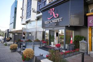 una tienda de jardín rojo en una calle de la ciudad con flores en Red Carpet Suites, en Amán