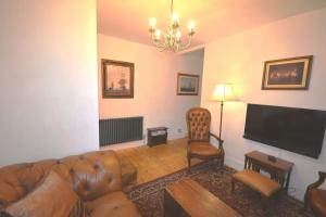 a living room with a couch and a flat screen tv at Delightful Cottage in Sandwich - One Bedroom in Sandwich