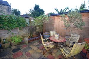 a patio with a table and chairs and a fence at Delightful Cottage in Sandwich - One Bedroom in Sandwich