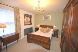 a bedroom with a bed and a chandelier at Delightful Cottage in Sandwich - One Bedroom in Sandwich