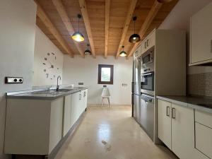 a large kitchen with white cabinets and a counter top at Casa Bella in Playa Migjorn
