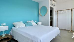 a blue bedroom with a white bed with a blue wall at CAP DE LA BARRA 61 - Villa deluxe vista mar in L'Estartit