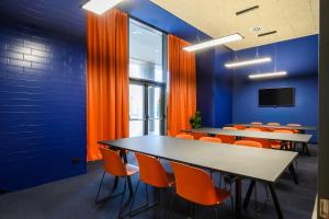 una sala conferenze con tavoli e sedie arancioni di CX Venice Mestre a Mestre