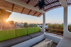 - un balcon avec vue sur une maison dotée d'un canapé dans l'établissement Suites La Hacienda, à Puerto Escondido