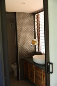 La salle de bains est pourvue d'un lavabo et de toilettes. dans l'établissement Sóc Sơn Homestay - Bird House, à Sóc Sơn