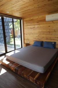 a bed in a room with a wooden wall at Sóc Sơn Homestay - Bird House in Sóc Sơn