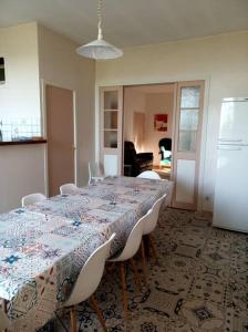 uma sala de jantar com uma mesa e cadeiras brancas em Maison familiale du Clos Saint Roch em Viviers