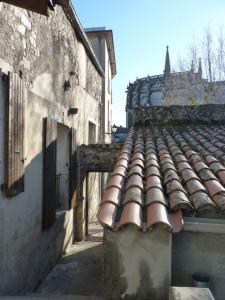 um edifício antigo com telhado de azulejo num beco em Maison familiale du Clos Saint Roch em Viviers