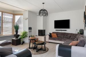 Wellness Landhuis Drenthe في Schoonloo: غرفة معيشة مع أريكة وتلفزيون