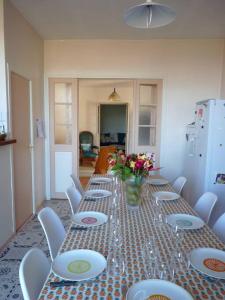 uma mesa longa com cadeiras e um vaso de flores em Maison familiale du Clos Saint Roch em Viviers