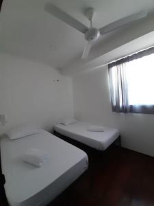 2 Betten in einem Zimmer mit Deckenventilator in der Unterkunft Apartamento Amoblado con Ventilador in Montería