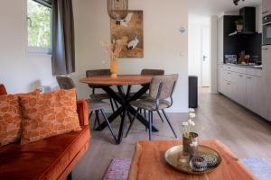 een woonkamer met een bank en een tafel bij Lodge Steltloper Nunspeet Veluwe in Nunspeet