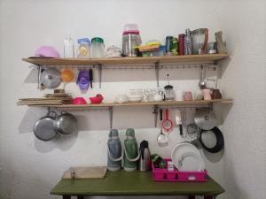 a room with shelves and a table with utensils at Randa's House I Homestay in Ruhengeri