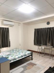a room with a bed and a table and chairs at Apartment near Train and Mall -Bangkok in Ban Khlong Samrong