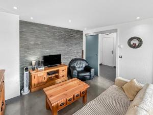 a living room with a couch and a tv at Escale Affaires Dugny-Bourget in Dugny