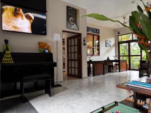 a living room with a piano and a table at Peacock Villa in Mirissa