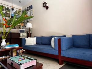 a living room with two blue couches and a table at Peacock Villa in Mirissa