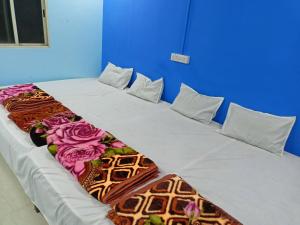 duże łóżko w pokoju z kwiatami w obiekcie M Baba Guest House w mieście Ujjain