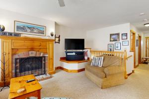 a living room with a couch and a fireplace at Jay Peak Village Home 375 in Jay
