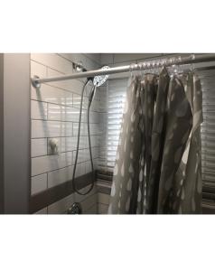 - Baño con cortina de ducha en Spotless 2 Bedroom Suite in Winnipeg, en Winnipeg