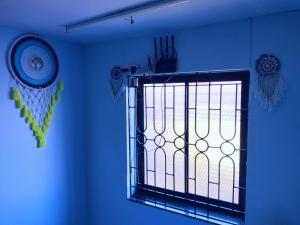 Beach Shalom Luxry Apartment and Villa Colva في كلفا: نافذة في غرفة ذات جدار أزرق