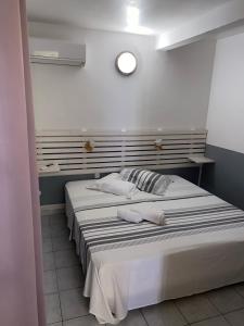 ein Schlafzimmer mit 2 Betten und einer Uhr an der Wand in der Unterkunft La Villa Davy in Ducos
