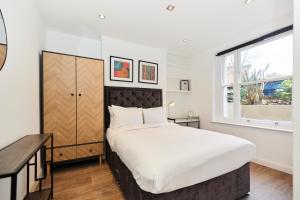 a bedroom with a large bed and a window at The Bermondsey Place - Cozy 2BDR Flat in London