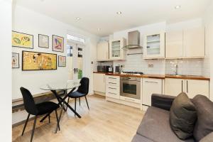 a kitchen with a couch and a table and chairs at The Bermondsey Place - Cozy 2BDR Flat in London