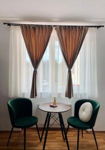 una stanza con due sedie e un tavolo e una finestra di SeTra Studio Poiana Brașov a Poiana Brasov