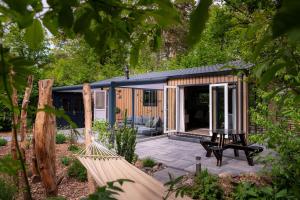 una piccola casa con amaca in giardino di Lodge Pimpelmees Nunspeet Veluwe a Nunspeet