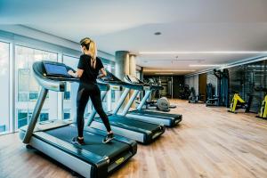 a woman running on a treadmill in a gym at SLS Buenos Aires Puerto Madero in Buenos Aires