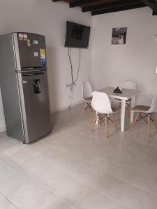 a kitchen with a refrigerator and a table with chairs at Apartamento Amoblado con Ventilador in Montería