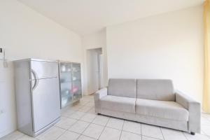 - un salon avec un canapé et un réfrigérateur dans l'établissement Tiepolo Apartments, à Lido di Jesolo