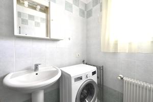 La salle de bains est pourvue d'un lave-linge et d'un lavabo. dans l'établissement Tiepolo Apartments, à Lido di Jesolo