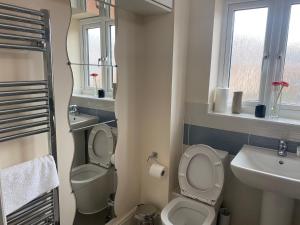 a bathroom with two toilets and a sink and a mirror at Spacious home for contractors and families in Sherborne Saint John +12 photos