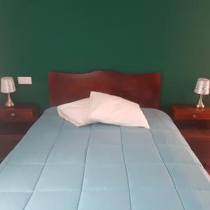a bedroom with a blue bed with two night stands at Vale dos Ilhéus in Machico