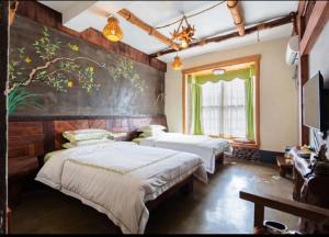 a bedroom with two beds and a painting on the wall at Butterfly Flowers Inn in Zhangjiajie